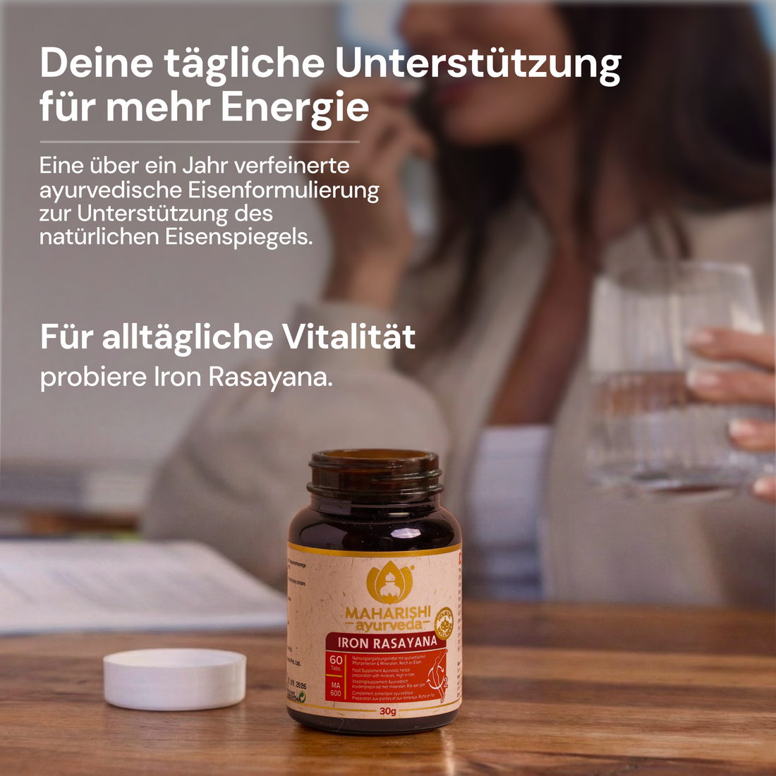 Iron-Rasayana-Flasche auf einem Tisch mit einer Frau im Hintergrund.
