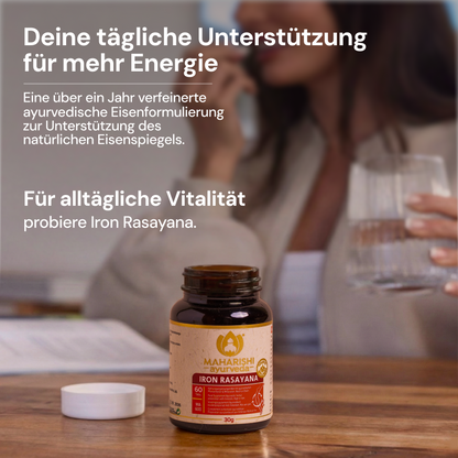Iron-Rasayana-Flasche auf einem Tisch mit einer Frau im Hintergrund.