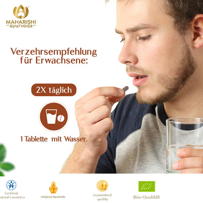 Mann nimmt eine Tulsi Tablette mit Wasser ein
