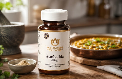 Asafoetida Hing Pulver neben dem Produkt und einem indischen Gericht