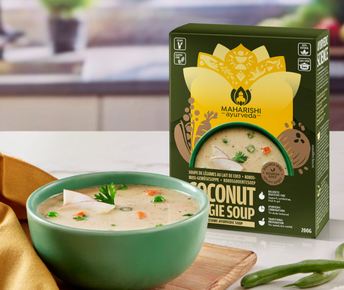 Kokosnuss-Gemüsesuppe mit Produktverpackung und frischem Gemüse